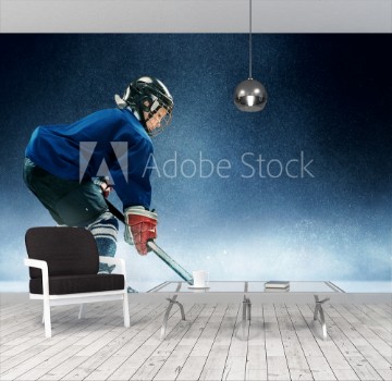 Picture of Little boy playing ice hockey at arena A hockey player in uniform with equipment over a blue background The athlete child sport action concept